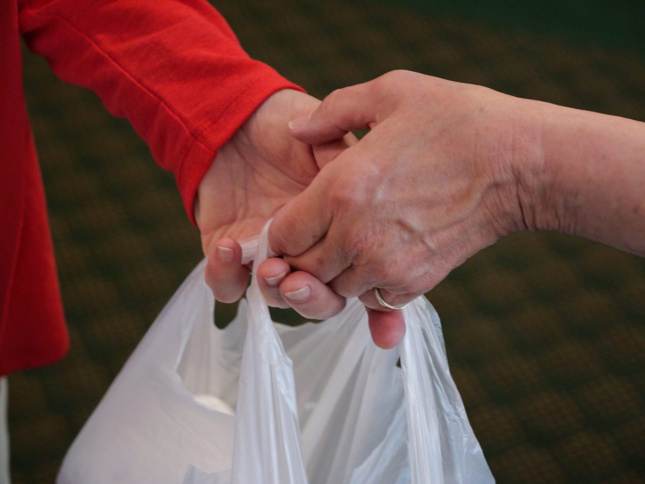 A person handing a bag of supplies